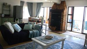 a living room with a couch and a fireplace at Anni's Guesthouse in St Helena Bay