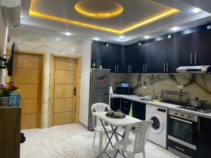 uma cozinha com armários pretos e uma mesa com cadeiras em Lagouira d'Agadir em Agadir