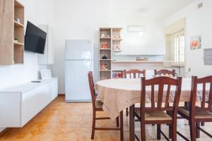 a kitchen with a table and chairs and a refrigerator at Villa Vimade con Piscina Privata in Marina di Mancaversa