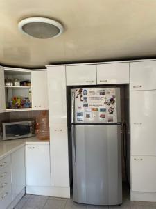 a refrigerator in a kitchen with white cabinets at Habitación con baño propio in Mexico City