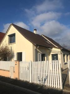 une clôture blanche devant une maison blanche dans l'établissement Maison de village près de Colmar de 90 m2, à Ungersheim