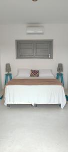 a bedroom with a large bed with two blue stools at Pontal Praia Suítes in Fortim