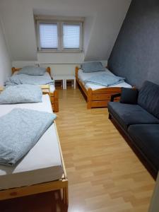 a room with three beds and a couch at Wohnung 6 Hagenerstr 72 Siegen 57072 in Siegen