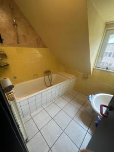 a bathroom with a tub and a sink at Wohnung 6 Hagenerstr 72 Siegen 57072 in Siegen