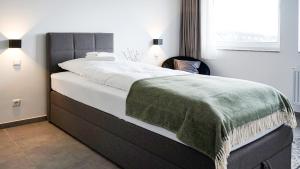 sypialnia z łóżkiem z zielonym kocem w obiekcie SI-View Einzelzimmer mit Stadtblick Zimmer 19 w mieście Siegen