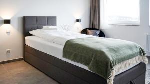 a bedroom with a bed with a green blanket on it at SI-View Einzelzimmer mit Stadtblick Zimmer 19 - Hotel in Siegen