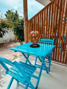 a blue table and two chairs on a porch at Pontal Praia Suítes in Fortim