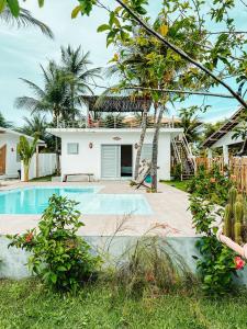 a villa with a swimming pool and a house at Pontal Praia Suítes in Fortim
