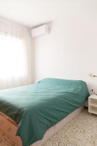 a bedroom with a green bed with a window at Hogar del Sur by Gades Gestión in Cádiz