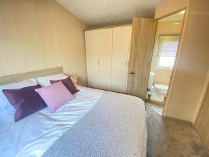 1 dormitorio con 1 cama grande con almohadas moradas en Caravan in morecambe en Morecambe