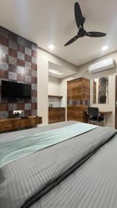 a bedroom with a large bed with a ceiling fan at Hotel Evanka in Indore