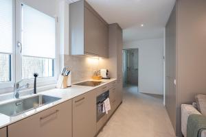 a kitchen with a sink and a counter top at STAYY Flagship Limmattal in Schlieren