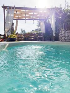 una piscina con pérgola y agua azul en Appartamento•Palermo, en Torretta