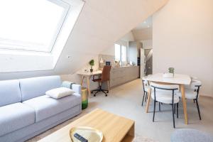 a living room with a couch and a table at STAYY Flagship Limmattal in Schlieren