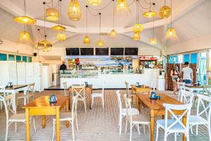 a restaurant with wooden tables and chairs and a bar at Hotel Altamarea Cesenatico in Cesenatico