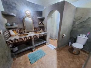 uma casa de banho com um lavatório, um WC e um espelho. em Dar S'BAH em Fez