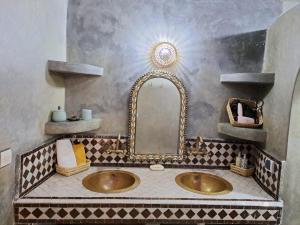 uma casa de banho com um lavatório e um espelho em Dar S'BAH em Fez