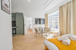 1 dormitorio con 1 cama y 1 mesa con sillas en Lovely & Exclusive Parisian Flat, en París