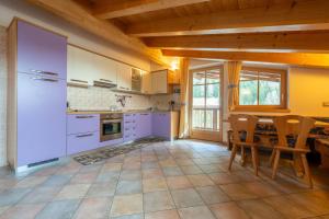 a kitchen with white appliances and a table with chairs at Casa dei Caprioli in Pera