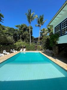 a swimming pool in front of a house at Hotel Solar das Águas Cantantes in Ubatuba