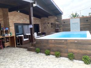 a large swimming pool in a house with a patio at Hostel Pé na Areia in Itanhaém