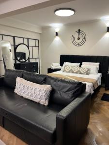 a black leather couch in a bedroom with a bed at מבית תכלת בית של חופש Allentown 21 אלנטאון 21 in Tiberias