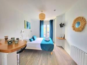 a bedroom with a bed and a table in it at Swann - A 2 pas de la plage ! in Saint Malo