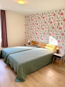 デュースブルクにある4 Rooms, free Parking, 25 min to Düsseldorf, 100 Mbps WLANの花柄の壁紙を用いたベッドルーム1室(大型ベッド1台付)