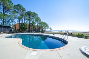 a swimming pool with a view of the beach at East End Beach Side Bungalow in Dauphin Island