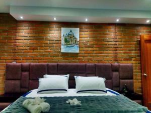 a bedroom with a large bed in a brick wall at Historic Cuenca Modern Loft in Cuenca
