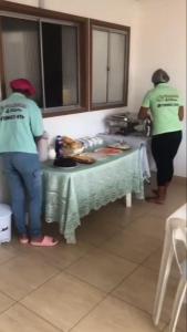 zwei Personen stehen um einen Tisch in einer Küche in der Unterkunft Pousada 4 estações in Madre de Deus