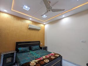 a bedroom with a bed and a ceiling fan at Central Residence in Gujrānwāla