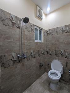 a bathroom with a toilet and a shower at Central Residence in Gujrānwāla