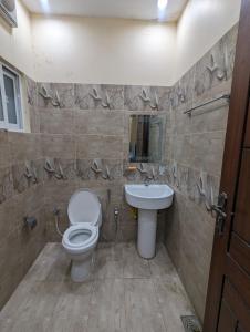 a bathroom with a toilet and a sink at Central Residence in Gujrānwāla