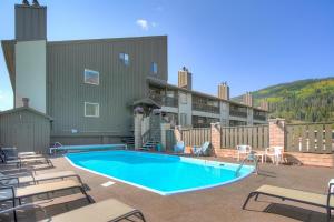 a swimming pool with chairs and a building at MTN View - Close to Lifts - Heated Pool - Copper in Wheeler Junction