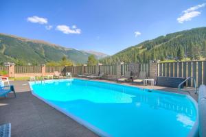 a large blue swimming pool with mountains in the background at MTN View - Close to Lifts - Heated Pool - Copper in Wheeler Junction