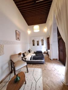 um quarto com uma cama, um sofá e uma mesa em Dar S'BAH em Fez