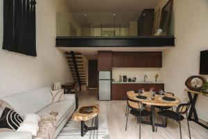 a living room with a couch and a table at Luxury Loft with Pools, Gym, Rooftop Terrace and Panoramic Views in Tulum