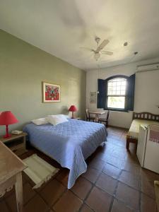 a bedroom with a bed and a table and a window at Hotel Solar das Águas Cantantes in Ubatuba