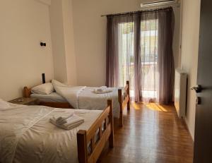 a room with three beds and a window at Navaro Apartments in Patra