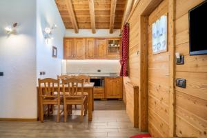 cocina con mesa y sillas en una habitación en Trilocale Chalet Camping Faè 6, en Madonna di Campiglio