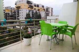 a balcony with a table and chairs and buildings at Vila Emi in Durrës