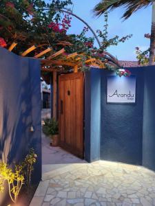 a blue wall with a door and a sign on it at Arandu Sagi Inn in Baía Formosa