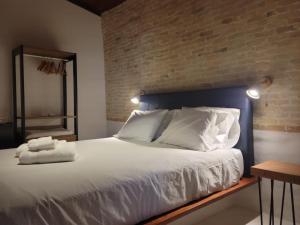 a bedroom with a large white bed with a brick wall at Arandu Sagi Inn in Baía Formosa