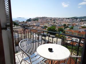 a white table and chairs on a balcony with a view at PensionMargaritaKotroniSkiathos in Skiathos
