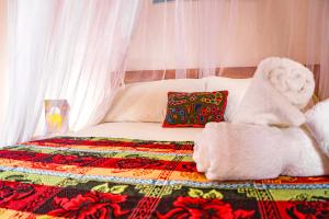 a bed with a stuffed animal sitting on top of it at Hotel Casa Canela By MH in Barichara