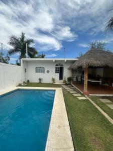 een huis met een zwembad en een rieten dak bij Casa Gaviota Casa Con Alberca y Palapa in Tequesquitengo