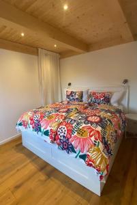 a bedroom with a large bed with a colorful comforter at Urlaub im Grünen - Charmantes Bauernhaus in Bad Waltersdorf