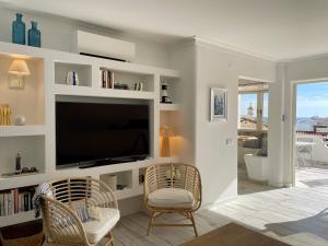 a living room with a flat screen tv and two chairs at Ocean Balcony apartment terrace sea view and pool in Albufeira