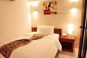 a hotel room with two beds and a table with a phone at ADAMAOUA GRAND HOTEL AKWA in Douala